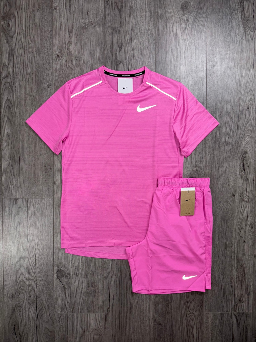 Pink Nike athletic shirt and shorts set on a wooden surface