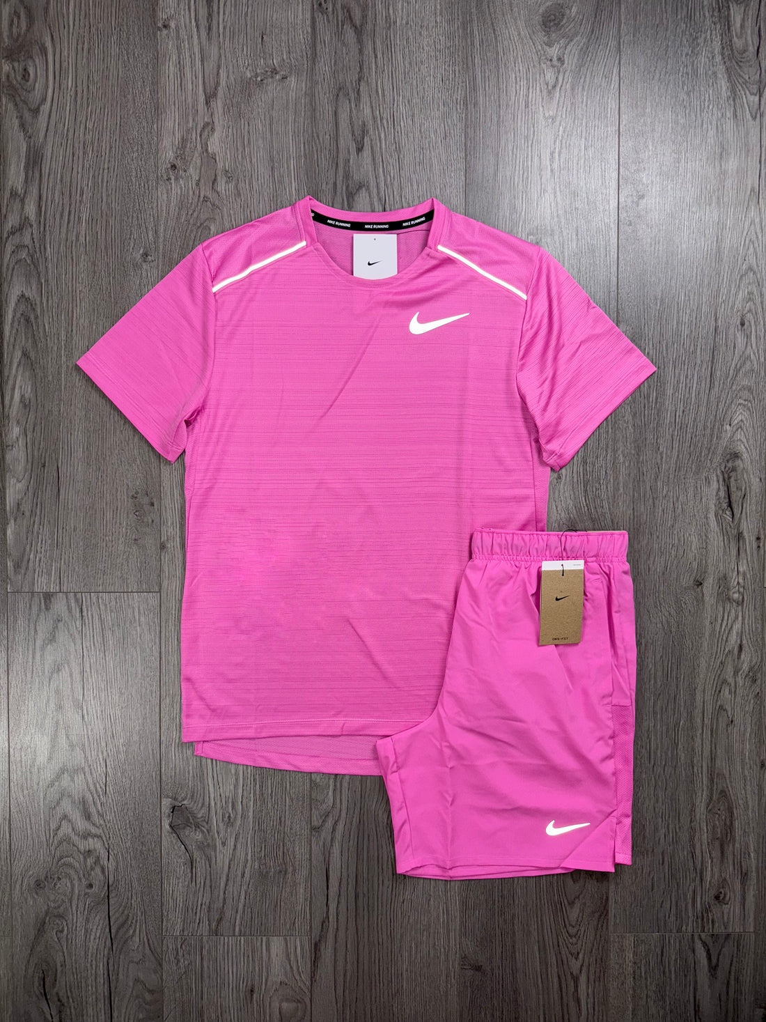 Pink Nike athletic shirt and shorts set on a wooden surface